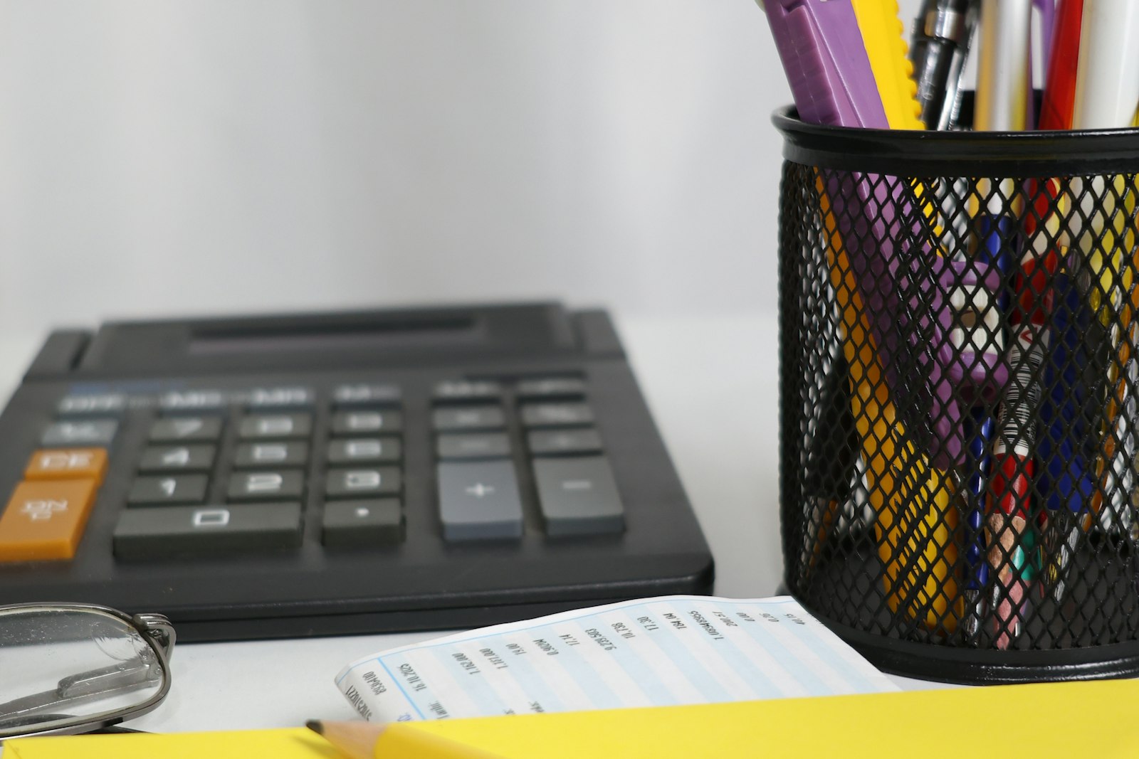Bureau avec calculatrice, stylos et enveloppe jaune